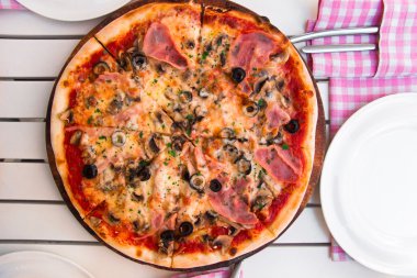 İtalyan lezzetli sıcak pizza beyaz masada ahşap plaka üzerinde