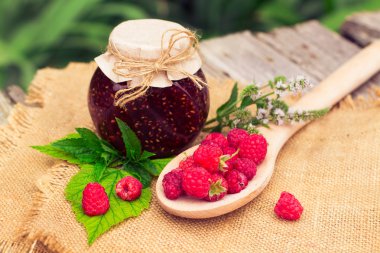 Fresh raspberries and jam on wooden table