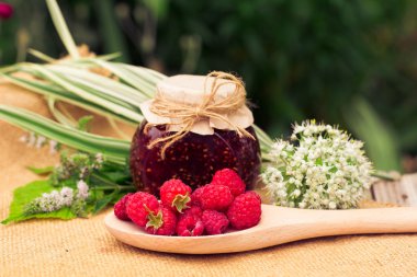 Fresh raspberries and jam on wooden table