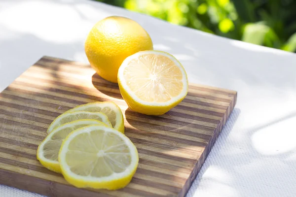 Tranches de citron frais sur une planche à découper — Photo