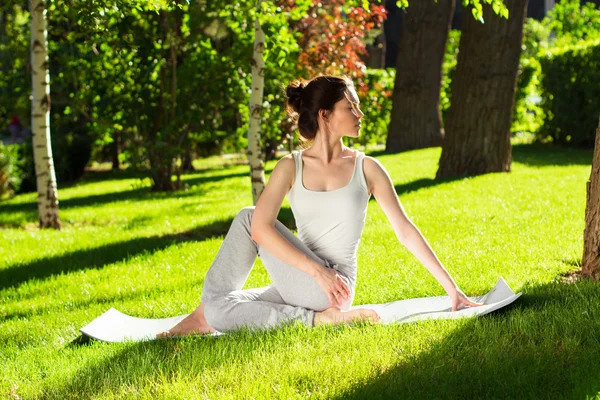 Young woman doing yoga in the park in the morning