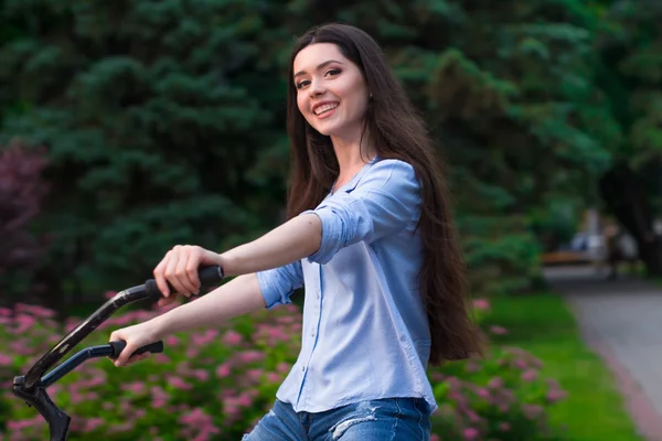 Красивая женщина с винтажным велосипедом в городском парке — стоковое фото