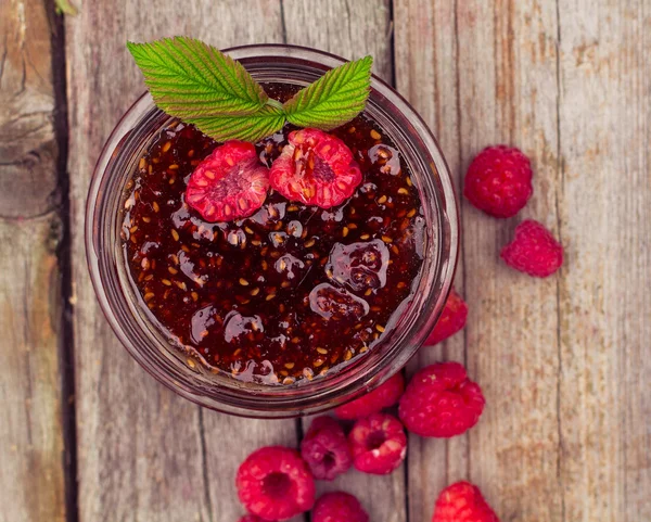 Frambozenjam in een kruik en verse bessen op de houten tafel — Stockfoto