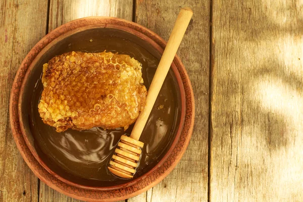 Honey in jar with honeycomb and wooden background. — Stok fotoğraf