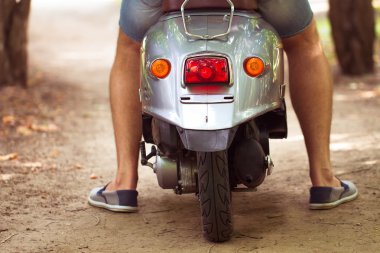 adam sürme eski retro scooter bir şehir sokakta. yakın çekim