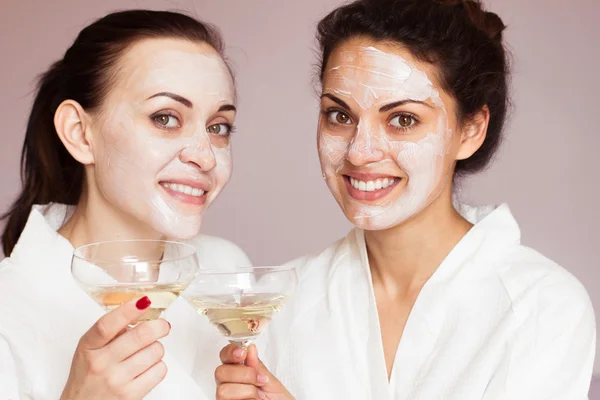 Smiling girlfriends with champagne in the spa
