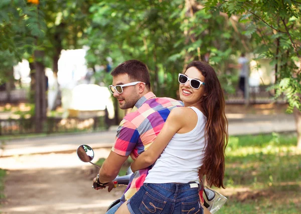 Andar de scooter juntos. Jovem casal montando uma scooter — Fotografia de Stock