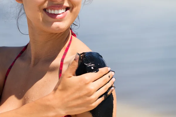 The curative mud on the skin of a beautiful young girl — Stock Photo, Image