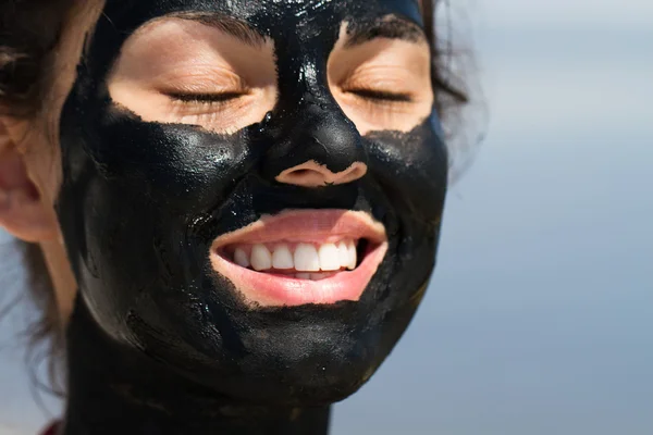 The curative mud on the skin of a beautiful young girl