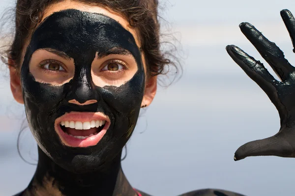 The curative mud on the skin of a beautiful young girl