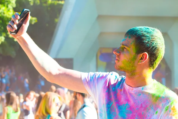 Teenager taking photo on mobile phone on holi color festival — Zdjęcie stockowe