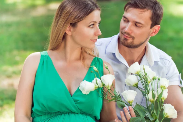 Junges schwangeres verliebtes Paar schaut einander an — Stockfoto
