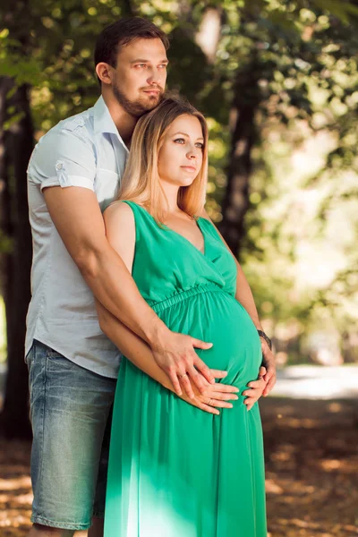 Gelukkige paar - man en zijn zwangere vrouw in de herfst park — Stockfoto