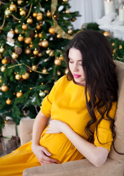 Genç güzel mutlu hamile kadın uzun sarı elbise siti — Stok fotoğraf