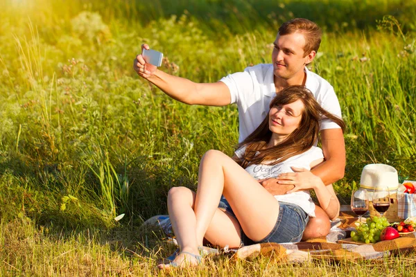 Unga vackra par i kärlek avkopplande på picknick utomhus — Stockfoto