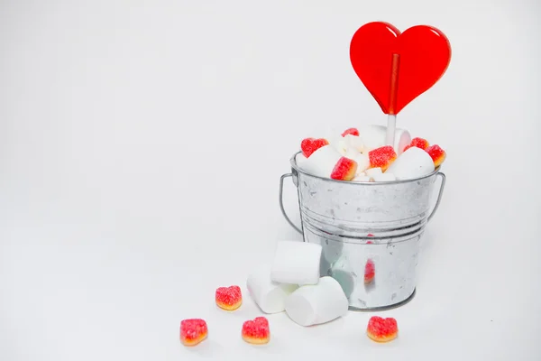 stock image Lollipop heart shaped in Small bucket with sweets on white backg