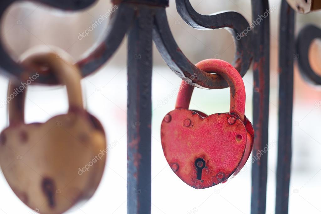 Vintage closed gold and red padlocks in heart shape Close Up on 