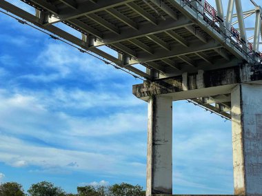 Kalimantan Nehri üzerindeki Kırsal Köprü Parlak Mavi Gökyüzü ve Huzurlu Doğa Görünümü