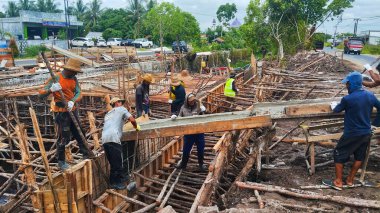 Beton Yol Yapımı: İnşaat Alanında Çelik Takviyesi Üzerine Karışımı Düzleştiren İşçilerle Karışık Kamyon Çimento Dökümü