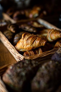 Pastanede kruvasanlar tezgahın üzerinde, rattan bir sepetin içinde.