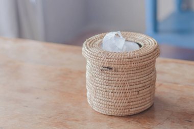 Açık kahverengi hasır sepet içinde beyaz kağıt ve açık kahverengi bir tahta masa üzerine yerleştirilmiş..