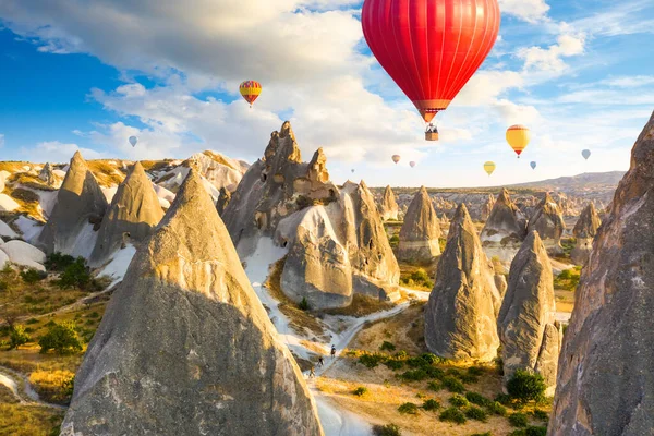 Hőlégballonok repülnek a sziklák felett Goreme falu közelében. Kappadocia. Törökország — Stock Fotó