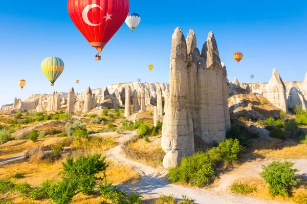 Balões de ar quente voando sobre o vale do amor perto da aldeia de Goreme. Capadócia. Turquia — Fotografia de Stock