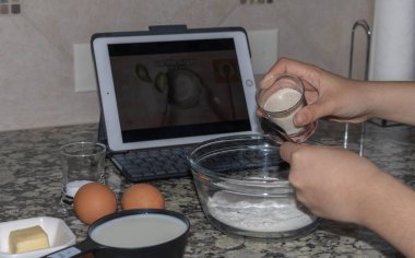 Ev hanımı evde online video izleyerek krep yapmayı öğreniyor.