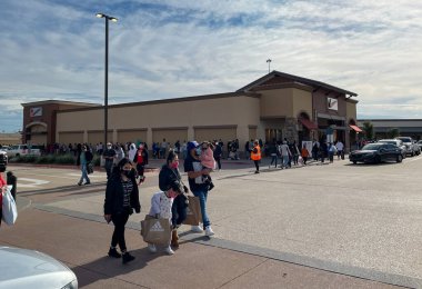 Allen, TX / USA - 27 Kasım 2020: Kara Cuma günü Allen Premium Prizleri 'nde maske takan ve alışveriş çantalarını taşıyan insanların manzarası