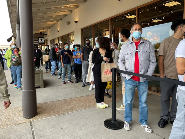 Allen, TX / USA - 27 Kasım 2020: Maske takan ve Kara Cuma günü Allen Premium Outlets mağazasının önünde kuyruğa giren insanların yakın görüntüsü