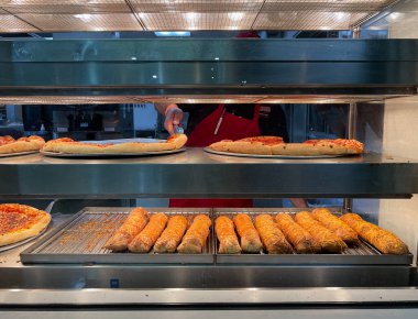 Signal Hill, CA USA - 20 Ocak 2021: Tepsiden pepperoni pizzasını alan bir çalışanla Costco yemek salonunun yakın görüntüsü