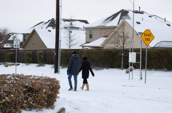 Mckinney, TX USA - February 17, 2021: Street view of Texas walking on the road after snowstorm