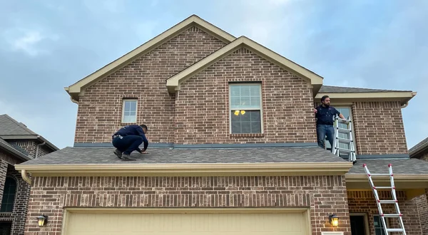 McKinney, TX USA - 1 Mart 2021: Çatı müfettişi dolu sonrası hasarı kontrol etmek için çatıya çıkıyor