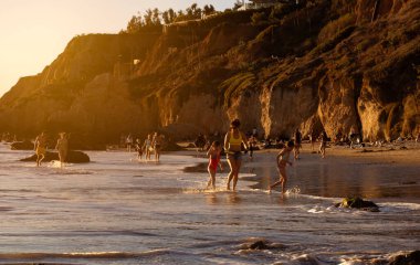 Malibu, CA USA - 1 Mart 2021: El Matador Plajı 'nda eğlenen insanların günbatımı