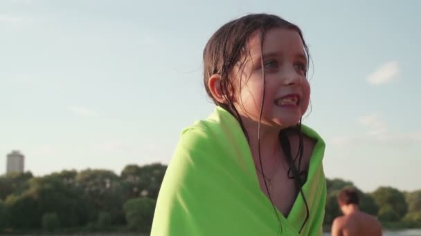 Menina bonita na toalha verde tremer todo depois de nadar — Vídeo de Stock