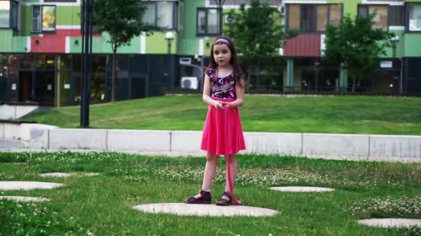 小さな女の子がロープ 3 で庭で遊んで. — ストック動画