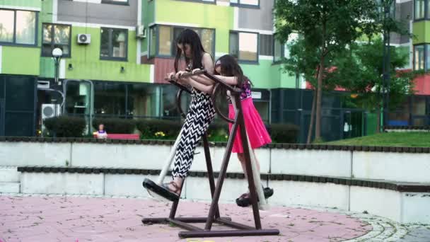 Two sisters playing in yard on fitness equipment 2 — Stock Video