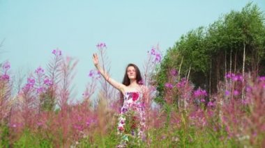 Genç güzel kız bir çayır ve dalgalar üzerinde ayakta