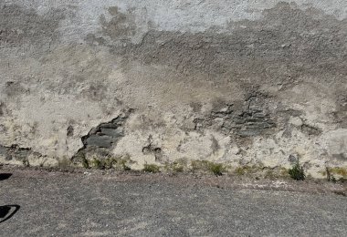 Eski, yıpranmış dış duvar, ağır hasarlı alçı ve duvarla kaplı. Yaşlanma, nem ve çürüme belirtileri var. Üs boyunca yosun ve küçük bitkiler büyüyor, bu da uzun süreli ihmalin göstergesi. Bir doku ya da arkaplan kadar mükemmel 