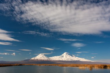 Snowy Ararat mountain in blue sky with foamy clouds clipart