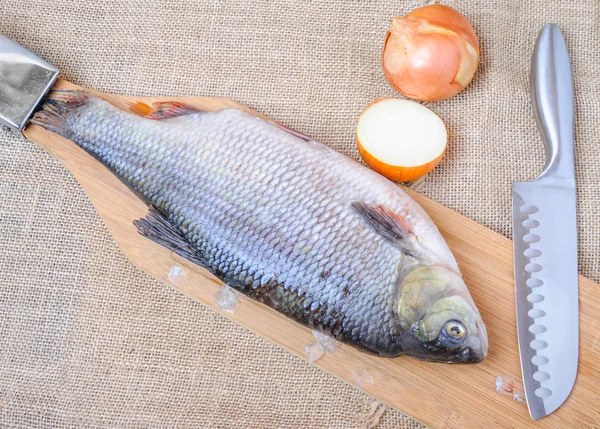 Peixe cru em uma tábua de corte — Fotografia de Stock