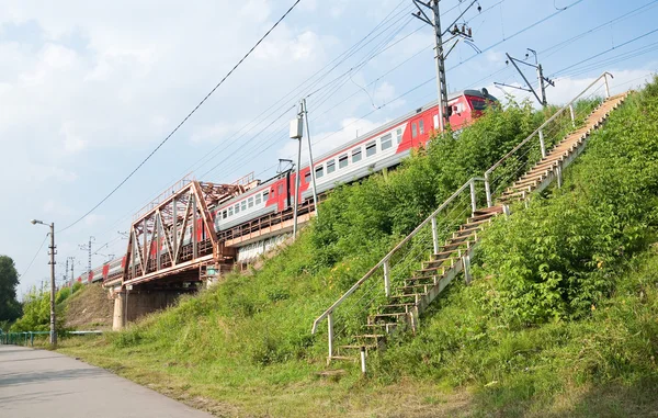 Train sur le pont ferroviaire Savelovsky direction à travers la rivière Klyazma en ville Dolgoprudny — Photo