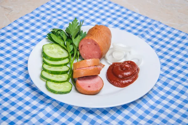 Salsicha cozida e legumes fatiados no prato — Fotografia de Stock