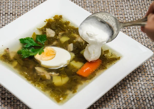 Der Zusatz von saurer Sahne in der Suppe — Stockfoto