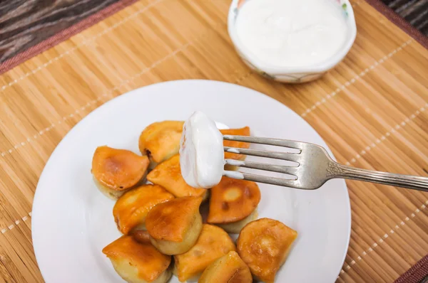 Dip de gefrituurde dumplings in zure room — Stockfoto