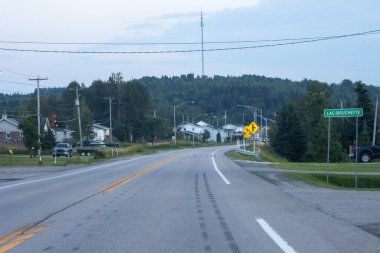 Kanada, 10 Ağustos 2025: Yeşil tepelerle çevrili Lac Bouchette köyüne doğru akşam sürüşü