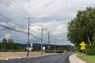 Kanada, 07 Eylül 2025: Taze asfalt yol, fırtınalı gökyüzü, motosikletler ve ağaçlar için ihtiyat.