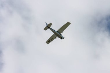 Kanada, 31 Ağustos 2025: Gri gökyüzünde beyaz bulutların üzerinde uçan küçük uçak