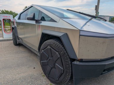 Kanada, 28 Temmuz 2025: Tesla şarj istasyonu bugün yol kenarına park edilmiş fütüristik bir araçla