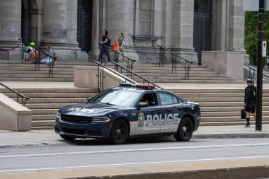 Quebec, Kanada, 05 Temmuz 2025: Devriye arabası merdivenleri olan büyük taş binanın yakınına park edildi